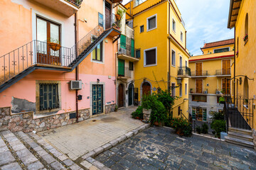 Fototapeta na wymiar Beautiful old town of Taormina with small streets, flowers. Architecture with archs and old pavement in Taormina. Colorful narrow street in old town of Taormina. Sicily, Italy.