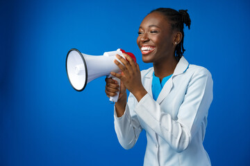 Afro american female doctor in white medical gown scream in megaphone in studio