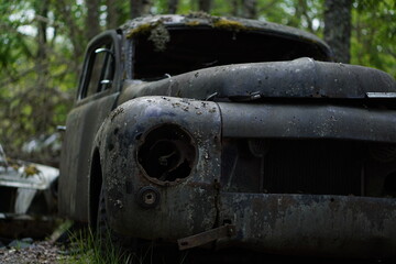 Old black rusted mossy car