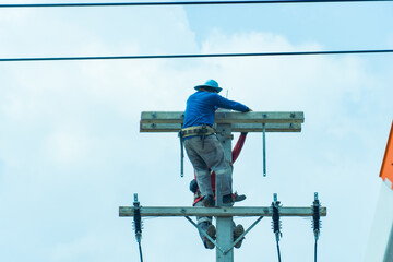 Technician on on the electric pole and repairing electrical wires on the highway