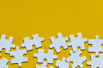 White jigsaw puzzle. White puzzle pieces on color background. Unfinished white jigsaw puzzle pieces on color background.