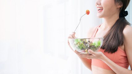 Portrait of Asian attractive woman hold salad bowl. Beautiful sport girl in sportswear enjoy eat...