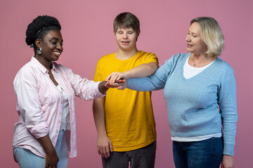 Two women and guy standing with outstretched arms