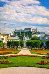 Fototapeta na wymiar Beautiful view of famous Mirabell Gardens with the old historic Fortress Hohensalzburg in the background in Salzburg, Austria. Famous Mirabell Gardens with historic Fortress in Salzburg, Austria.