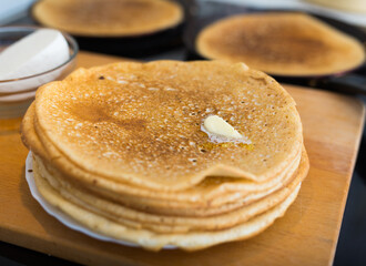 stack of appetizing flour pancakes in the kitchen during cooking