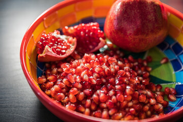 Ripe pomegranate fruit in a jar on wooden vintage background