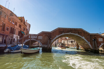 Naklejka premium Venice downtown. Bridge of the Three Arches (Ponte dei Tre Archi or di San Giobbe), 1688, made of brick and stone, over the Cannaregio canal of the Venetian lagoon. Veneto, Italy, Europe. 