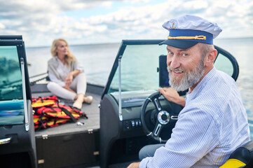 A mature couple sailing on a boat and looking happy