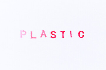 Red color ink rubber stamp in word plastic on white paper background