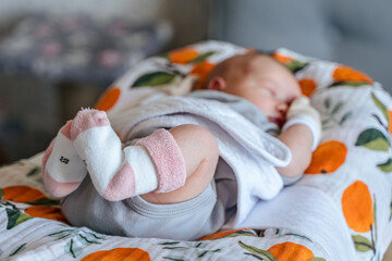 Socks on the legs of a newborn baby, the first day at home after the maternity hospital, focus on the legs