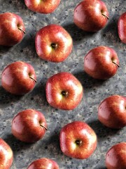 Pattern of red apples on black concrete background. Creative 3d flatlay with summer fruit.
