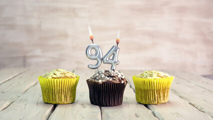 Happy birthday muffins with candles with the number 94. Card copy space with pies for...