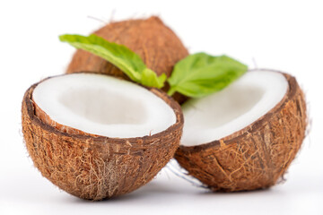 Fresh and tasty coconuts whole and cut in half, healthy food, close-up with small depth of field isolated
