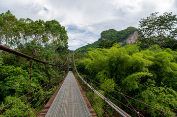 Fototapeta na wymiar Suspension bridge heart shaped mountain at Surat Thani, Thailand