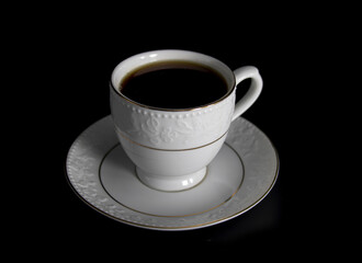 Porcelain cup of tea with tea isolated on black background, selective focus