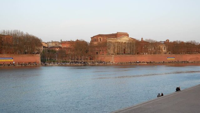 Panning view of Pont Neuf bridge, Notre Dame de la Daurade Basilica and Garonne river banks in Toulouse, France