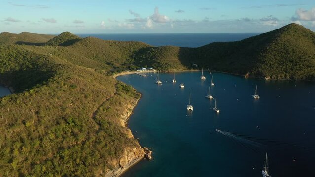 Aerial: British Virgin Islands - Orbiting view of Normand Island at sunset. 