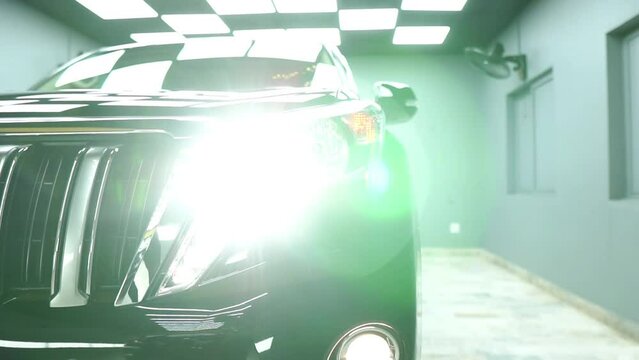 Close  up shot of on head light of land cruiser. Close up shot of Fortuner cruise headlight blinking.