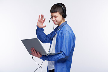 Young teenage boy using his laptop, working on his school work or taking an online class