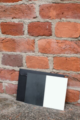 Mockup friendly vertical template of postcard certificate with black envelope on a brick wall background