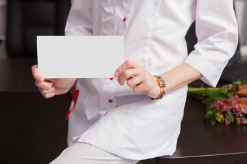 Close-up of female doctor hands holding mockup friendly template of postcard certificate