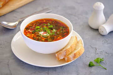 Beetroot soup with herbs and garlic on a light background.