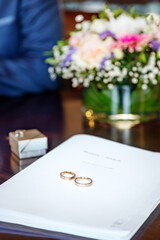 Prenuptial agreement with a pair of wedding rings and flowers background.