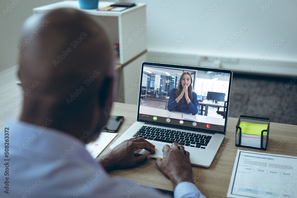 Wall mural Multiracial businessman and businesswoman planning work strategies while working through laptop