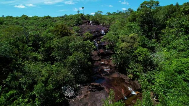 The river of seven colors Ca&ntilde;o Cristales, which is crossed by a white long bridge connecting the two banks of the nature reserve, Colombian river located in the Sierra de la Macarena 