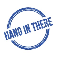 HANG IN THERE text written on blue grungy round stamp.