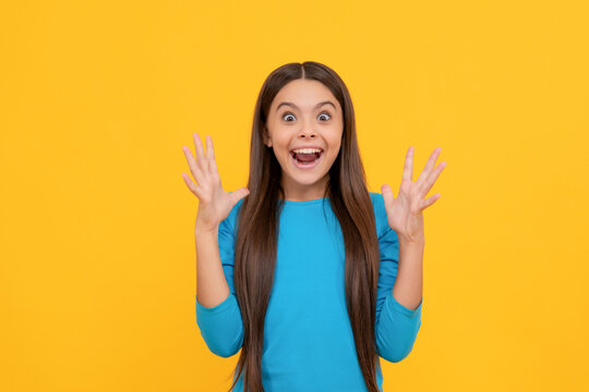happy shocked kid with long hair on yellow background, wow