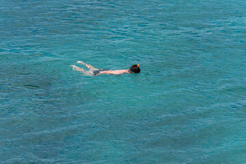 people snorkeling in the sea, watching marine life on the shores of the galapagos islands