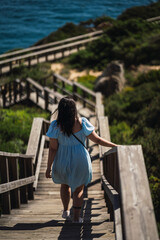 Chica guapa joven posando alegremente junto a un faro en la costa de andalucia