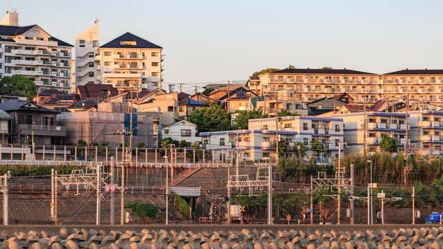 Time lapse of trains moving by condo development in late afternoon