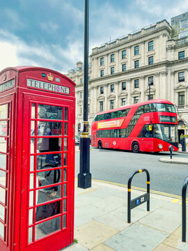 Two Iconic London Trademarks, The Classic Red, Enclosed Phone Booth And A Red Double Decker Bus