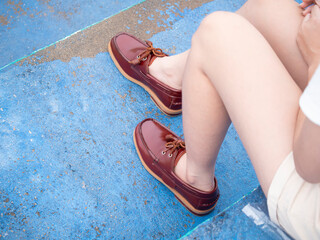 Female fashion in boat shoes leather, Close up view on woman's legs in red shoes leather.