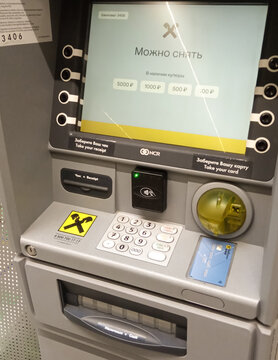 Raiffeisen Bank ATMs in Metro Cash & Carry store. Close-up of monitor and keyboard. On walls of ATM, painted in corporate gray, tlogo of Raiffeisen Bank is placed. Krasnodar, Russia - May 19, 2022.