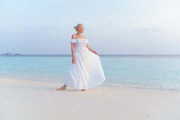 Fototapeta na wymiar A woman in a white dress on the ocean.