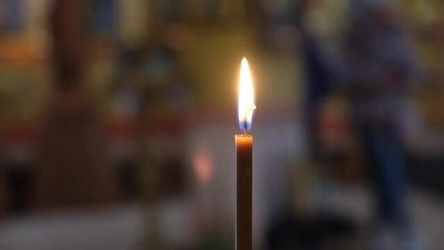 Burning church candle in the Orthodox cathedral. The concept of Christianity, rituals, beliefs, religions, prayers, funeral services for health and for the repose.