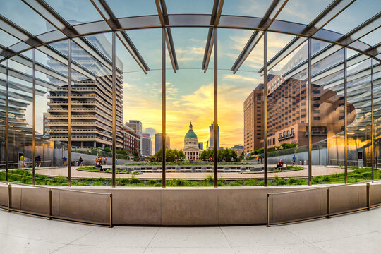 ST. LOUIS, MO, USA - AUGUST 8, 2018: The Gateway Arch Office features tours, cruises, and history lessons for those looking to visit, located below the arch. A sunset fills the sky.
