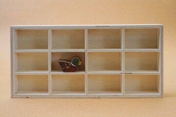 Twelve Compartment Shadow Box with Wooden Duck Figure on Pale Orange Background
