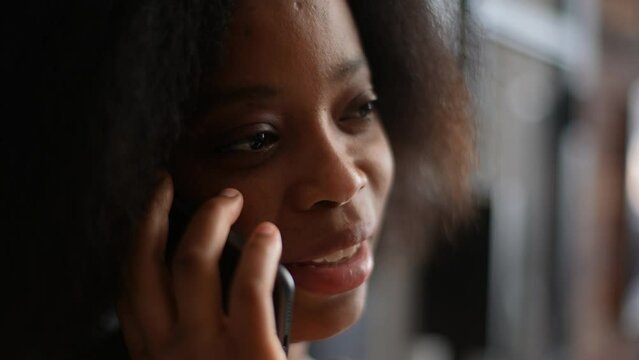 Close-up Face Of Pretty Laughing African-American Woman Talking On Mobile Phone With Friend, Boyfriend, Family From Home. Closeup Of Cheerful Curly Young Lady Speaking On Smartphone, Slow Motion.