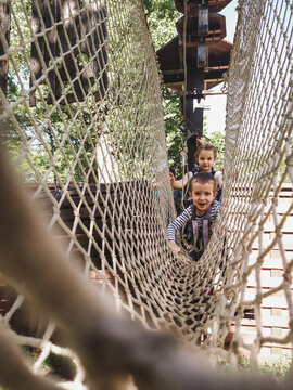 Joyful children in a net in a rope park