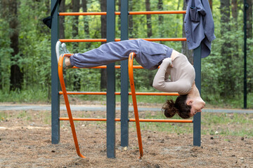 Fototapeta premium Fitness sport girl in fashion sportswear doing yoga fitness exercises on the street, outdoor sports, urban style. Portrait of romantic woman at fairy forest. Girl purple suit. Corduroy fabric 