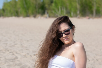 Female fashion model at sandy beach on beautiful sunny day.  sea background. 