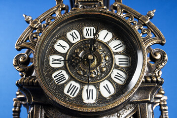 dial of vintage bronze clock, antique clock photo close up, old bronze clock in gilding, front of bronze fireplace clock