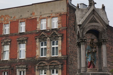 Fototapeta na wymiar Historic wayside shrine on a city street, religious depiction by road. Bytom, Poland.