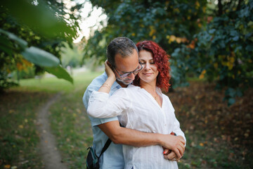 Fototapeta premium Cute middle aged european couple hugging in the park