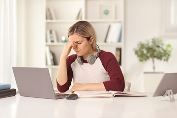 Tired female student studying in front of a laptop computer