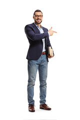 Full length portrait of a young man with glasses holding books and pointing